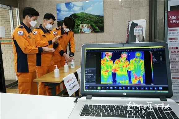 소방재난본부 청사 입구에 설치된 열화상카메라를 통해 출입자의 체온을 확인하고 있다.