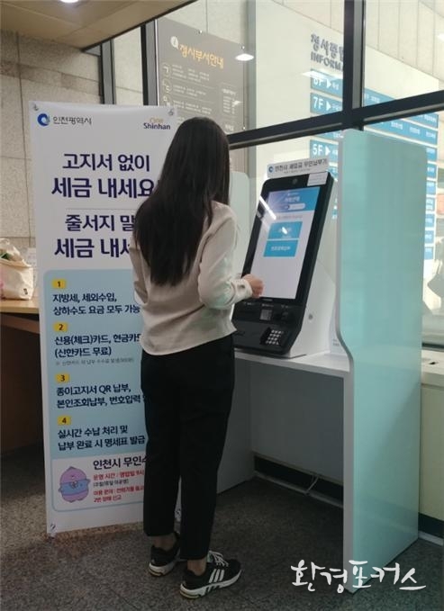 부평구청에 시범설치 한 무인수납기를 이용해 한 시민이 지방세를 납부하고 있다.