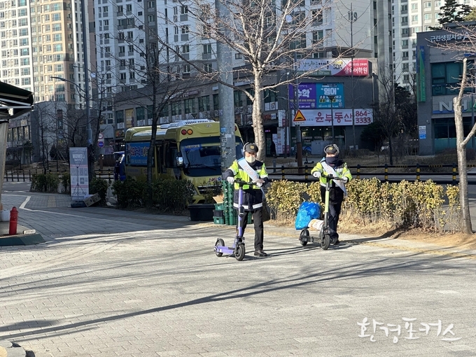 모범운전자회 서포터즈가 인하대학교 역사 주변 PM 기기를 정리하고 있다.