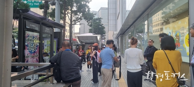 중구 명동 일대 무자격 가이드 합동 단속 사진 - 가이드 자격증 조회 앱을 통해 자격증 확인